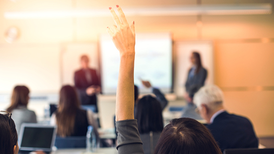 A student raises her hand during the Custom Leadership Program as a part of Northwestern University's Master of Science in Communication